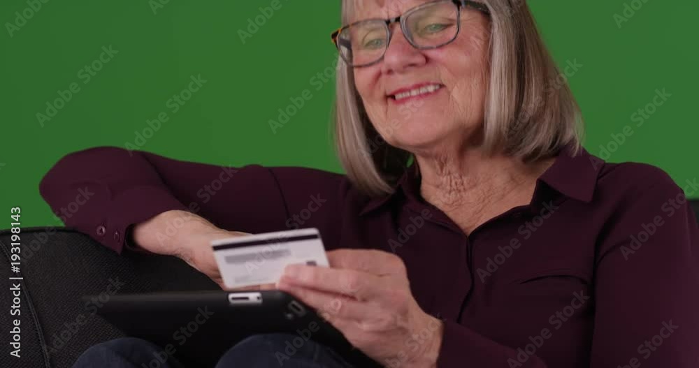 Tight shot of happy retired woman making online payment on green screen Tight shot of happy retired woman making online payment on green screen