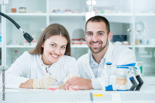 Young team of dental technicians making teeth prostetics. Process of making denture.