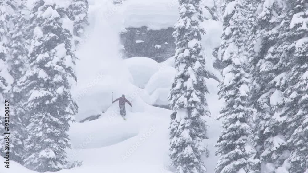 Skier makes run down snowy mountain, slow motion Skier makes run down snowy mountain, slow motion