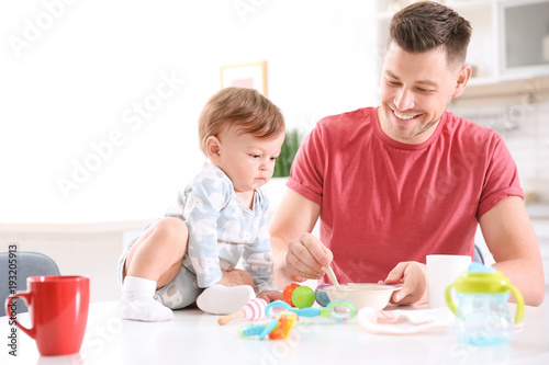 Father feeding his little s...