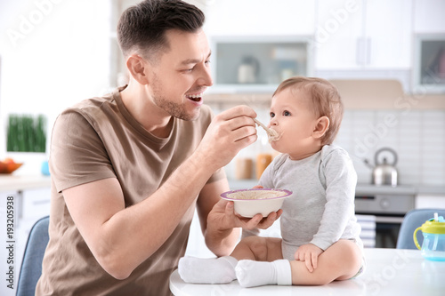 Father feeding his little s...