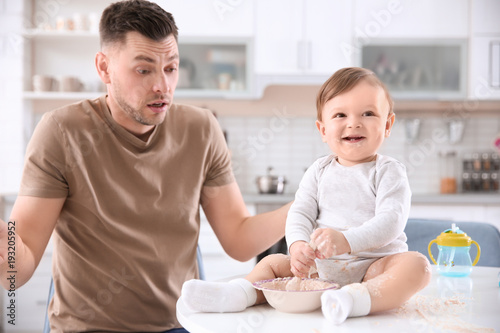 Father feeding his little s...