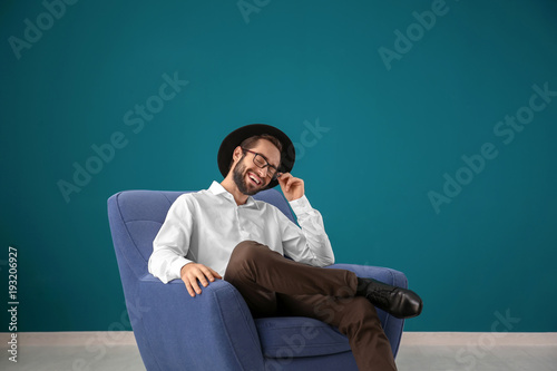 Handsome man sitting in com...
