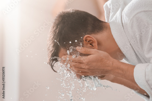 Fototapeta Naklejka Na Ścianę i Meble -  Man spraying water on his face after shaving in bathroom