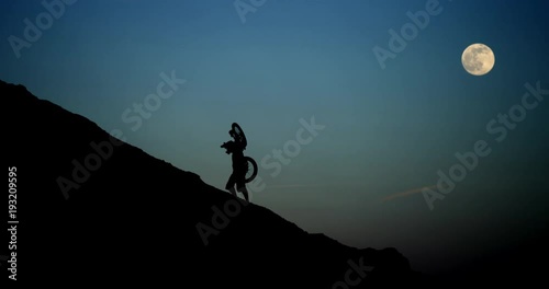 Mountain biker travels uphill, Utah moon sky