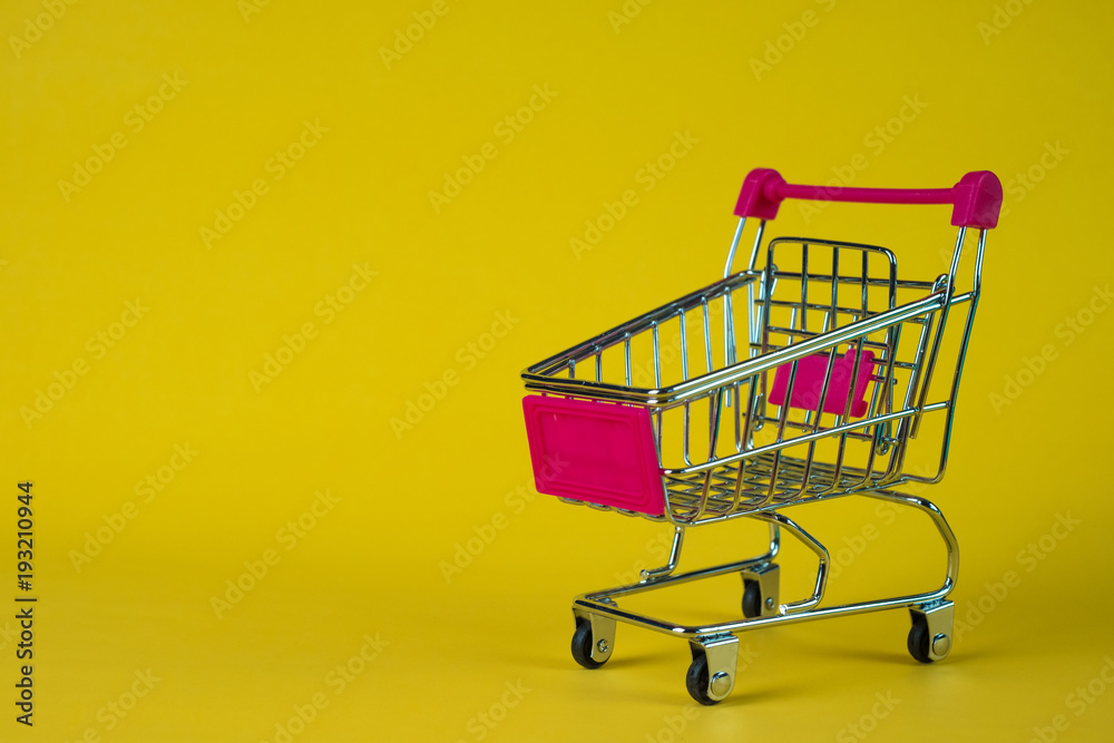 Shopping cart or supermarket trolley on yellow background, business finance shopping concept.