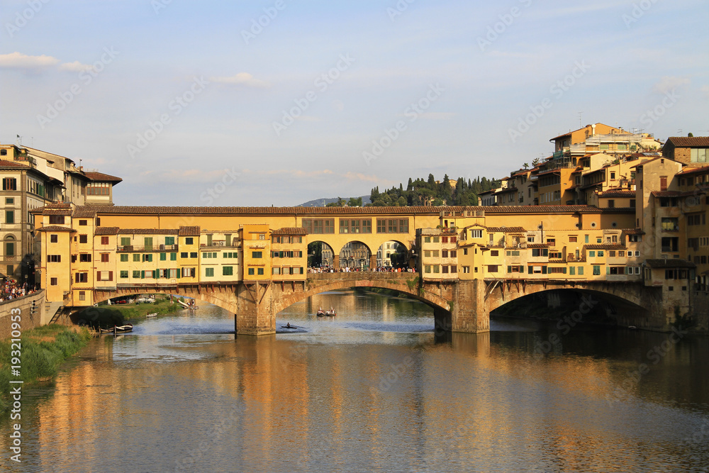 River Arno and stone bridge with shops built along it, Ponte Vecchio (Old Bridge), during the sunset, Florence, Tuscany, Italy.