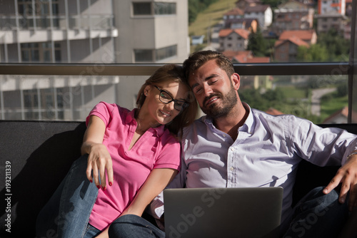 couple relaxing at home using laptop computers