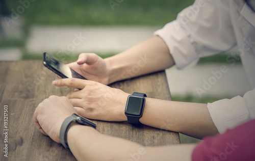 Close up men using amartphone and wearing smartwatch sharing activities information