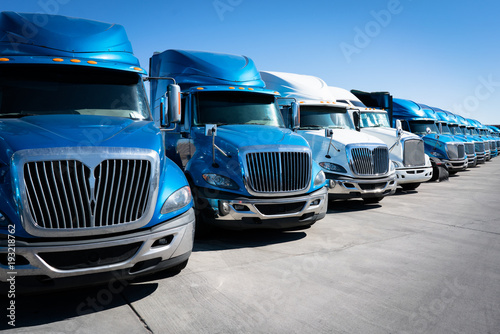Fleet of blue 18 wheeler semi trucks