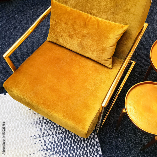 Retro style dark yellow velvet armchair and golden side table