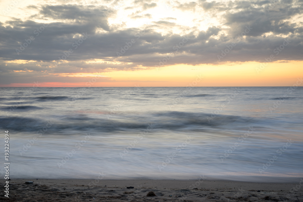 Horizontal line of the sea at sunrise, long exposure , dramatic wave