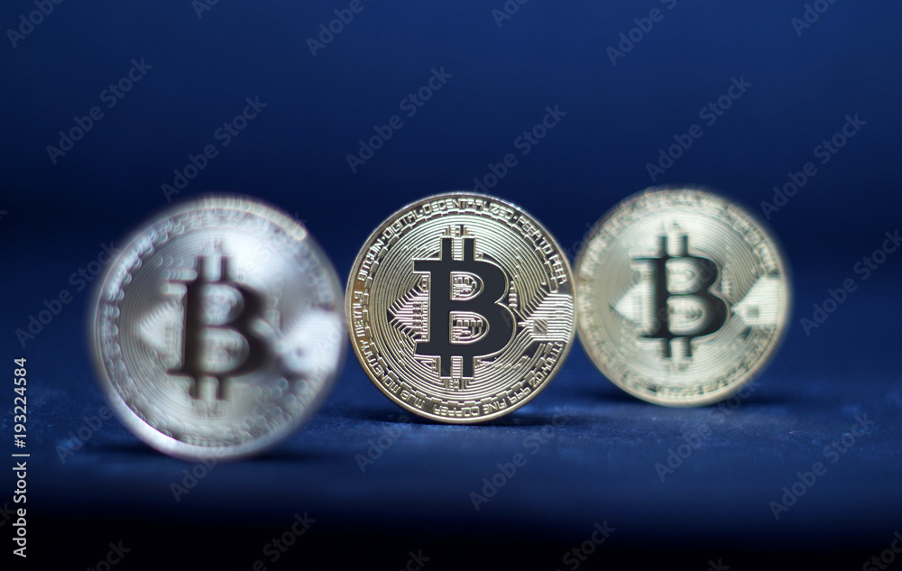 Three coins of bitcoin on black background.