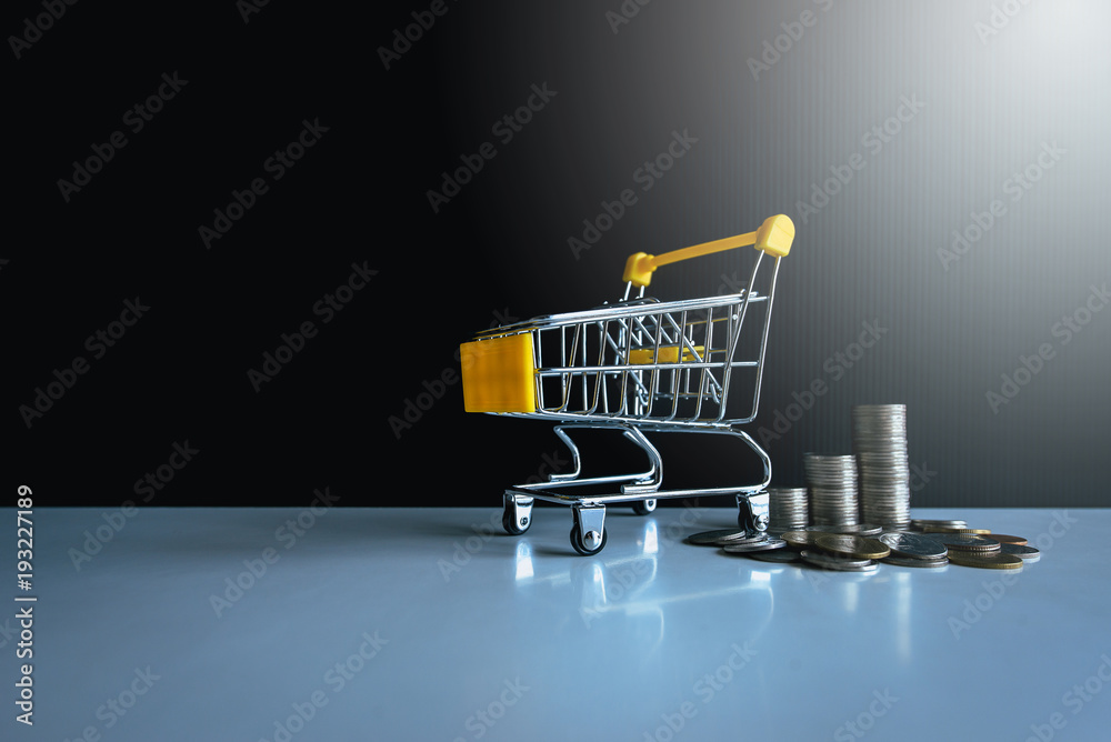 Mini shopping cart with coins stacks,Finance and money shopping concept