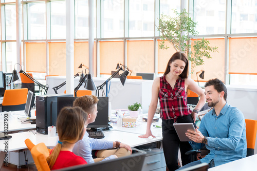 startup business, young creative people group brainstorming on meeting at office interior and using laptop and tablet computer to note ideas plans and projects