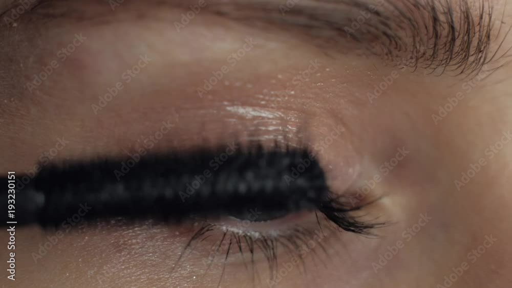 Extreme close-up - The female apply makeup on her eyes. Macro footage. 4k