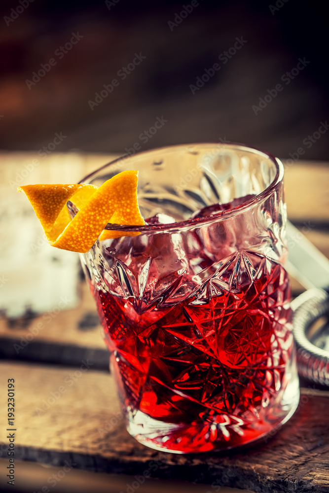 Foto Stock Cocktail Negroni on a old wooden board. Drink with gin, campari  martini rosso and orange | Adobe Stock