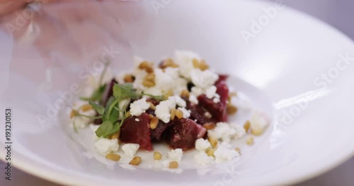 4K Close up on gourmet dish being given finishing touches by skilled chef. Could be professional kitchen or someone preparing for a dinner party. photo