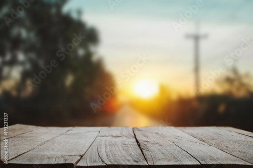 Wood table top in front of of trees in the forest. blur background image, for product display montage in morning light
