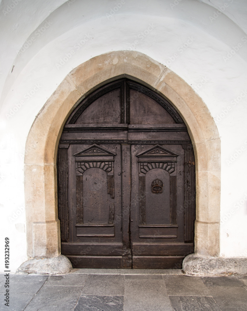 ancient wooden door with knocker and closing mechanism