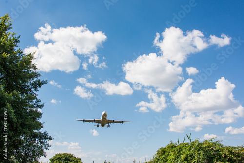 Airplane landing. Clouds and blue sky background, with copy space