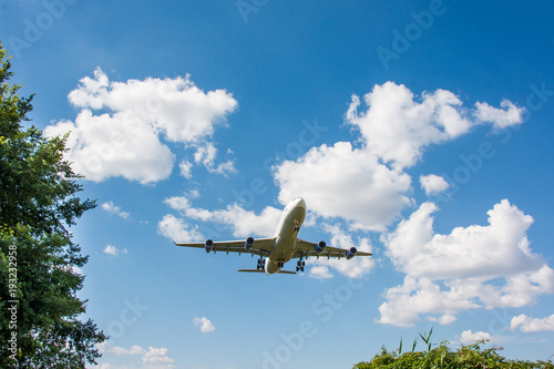 Airplane landing. Clouds and blue sky background, with copy space