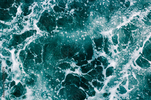 The surface of the sea with waves,  splash,  foam and bubbles, green abstract background © Bogdan