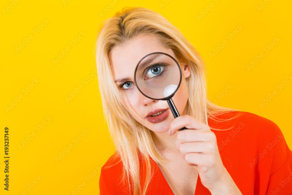 Blonde woman in dress with magnifying glass Blonde woman in dress with magnifying glass