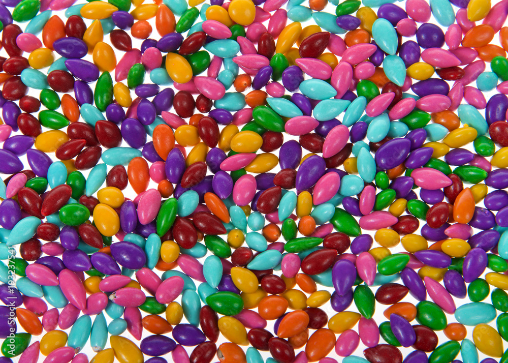 Background of candy coated sunflower seeds coated in smooth milk chocolate and a beautiful rainbow candy shell.