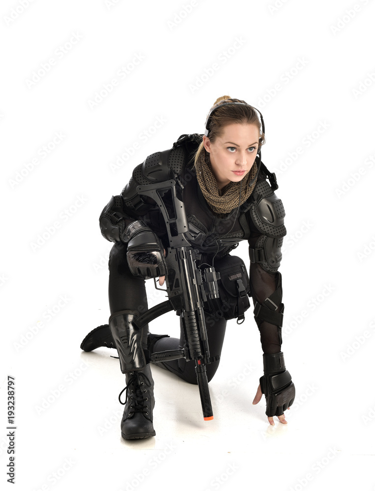 full length portrait of female wearing black tactical armour, crouching pose  holding a weapon, isolated on white studio background. Stock Photo | Adobe  Stock