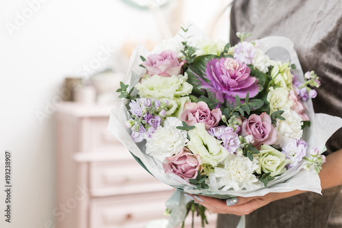beautiful luxury bouquet of mixed flowers in woman hand. the work of the florist at a flower shop. © malkovkosta