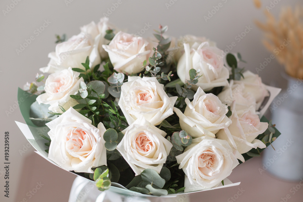 beautiful luxury bouquet of white rose on wooden table. the work of the florist at a flower shop. David Austin beautiful luxury bouquet of white rose on wooden table. the work of the florist at a flower shop. David Austin