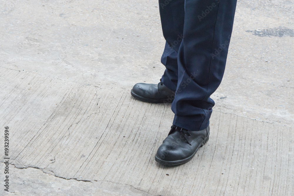 Leg of man with long black trousers standing on the street., business men shoes stand on walking street Leg of man with long black trousers standing on the street., business men shoes stand on walking street