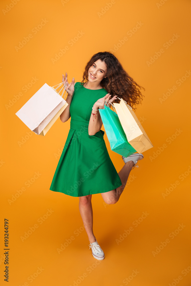 Happy young woman holding shopping bags.