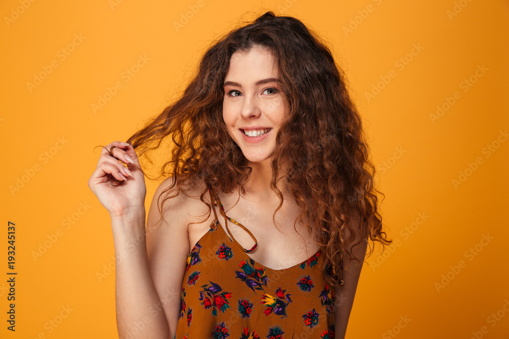 Obraz premium Cute young lady standing isolated over yellow background
