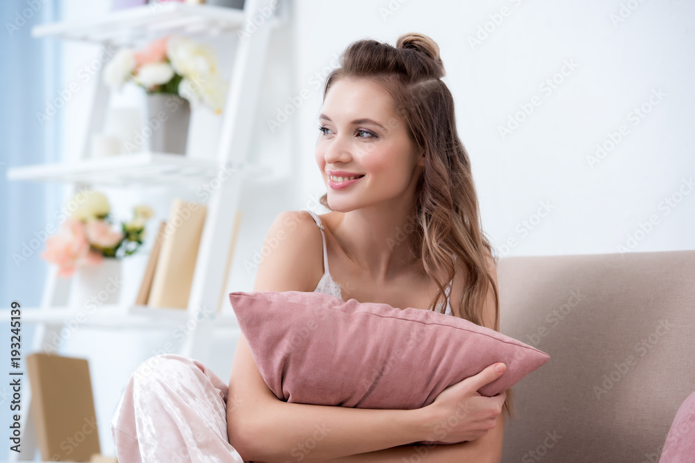 beautiful smiling girl in pajama holding pillow and looking away at home beautiful smiling girl in pajama holding pillow and looking away at home