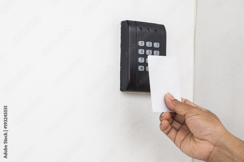 Door access control - young woman holding a key card to lock and unlock door., Keycard touch the security system to access the door Door access control - young woman holding a key card to lock and unlock door., Keycard touch the security system to access the door