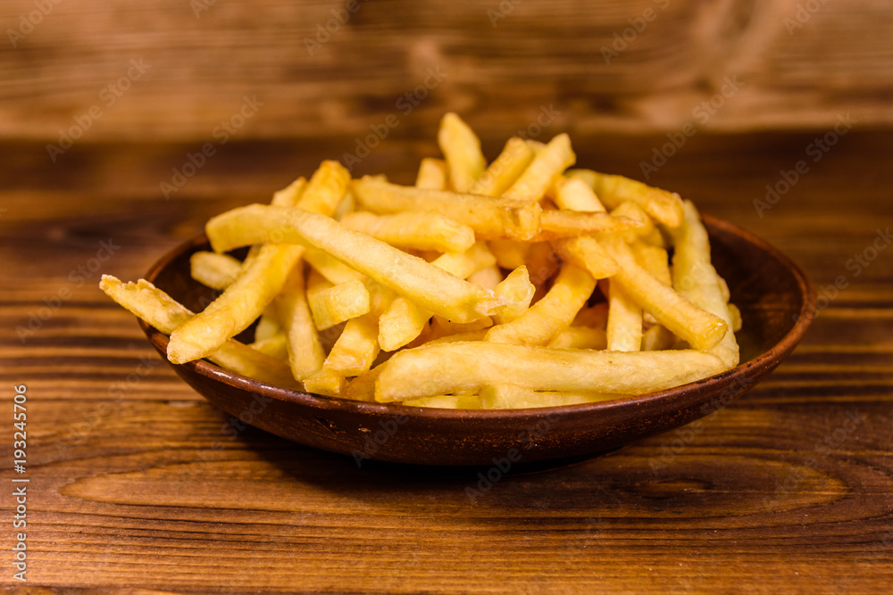 Ceramic plate with french fries on wooden table Ceramic plate with french fries on wooden table