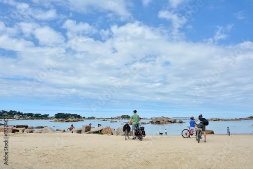 Une famille de randonneurs en vélo sur la côte de granit rose en Bretagne