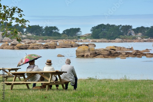 Des personnes qui sont assises sur un banc regardent la mer en Bretagne