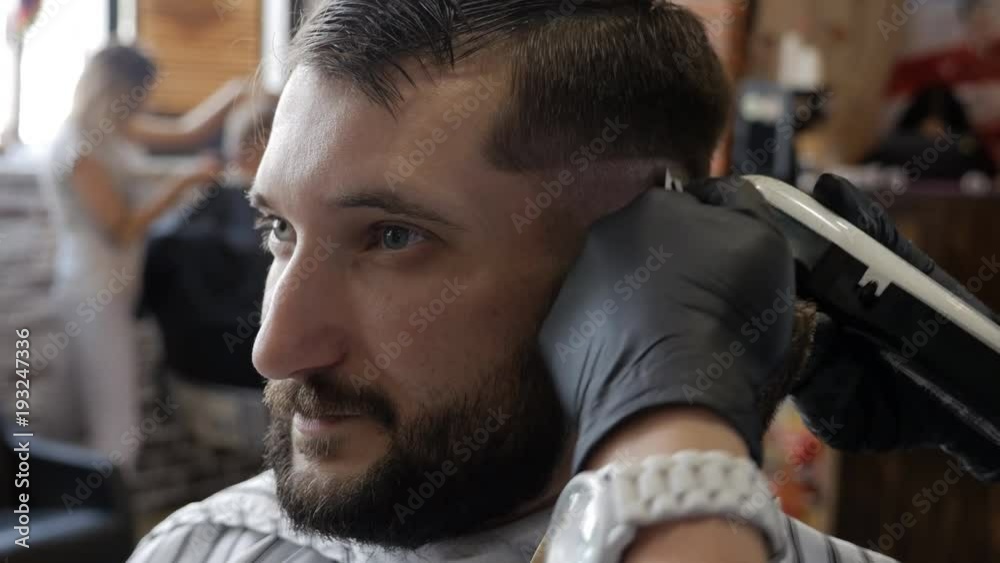 Man hands grooming man hair in barber shop Man hands grooming man hair in barber shop