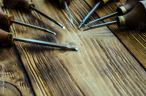 Different gravers for jewelry on wooden background