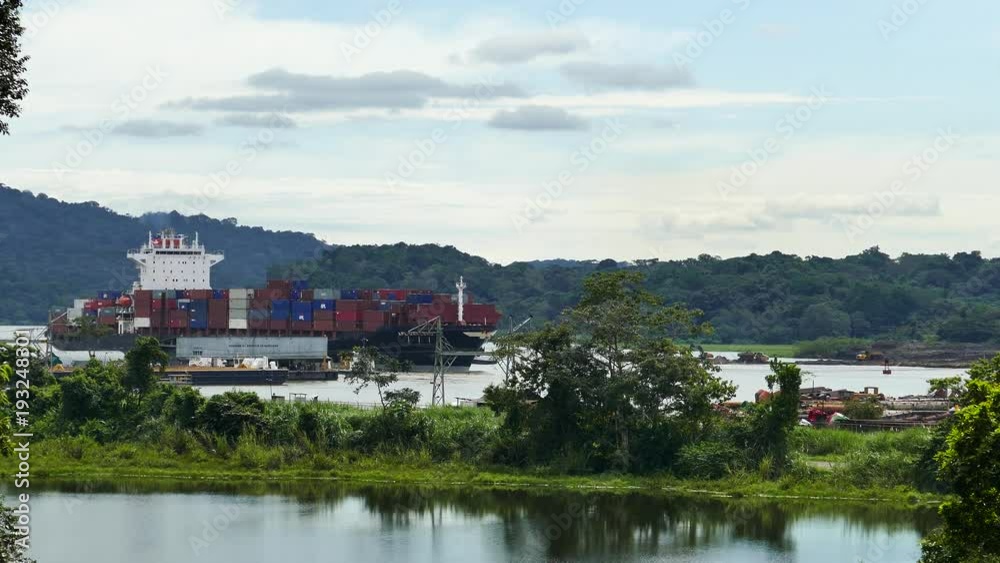 Cargo ship sailling through the Panama Canal with jungle and mountains Cargo ship sailling through the Panama Canal with jungle and mountains