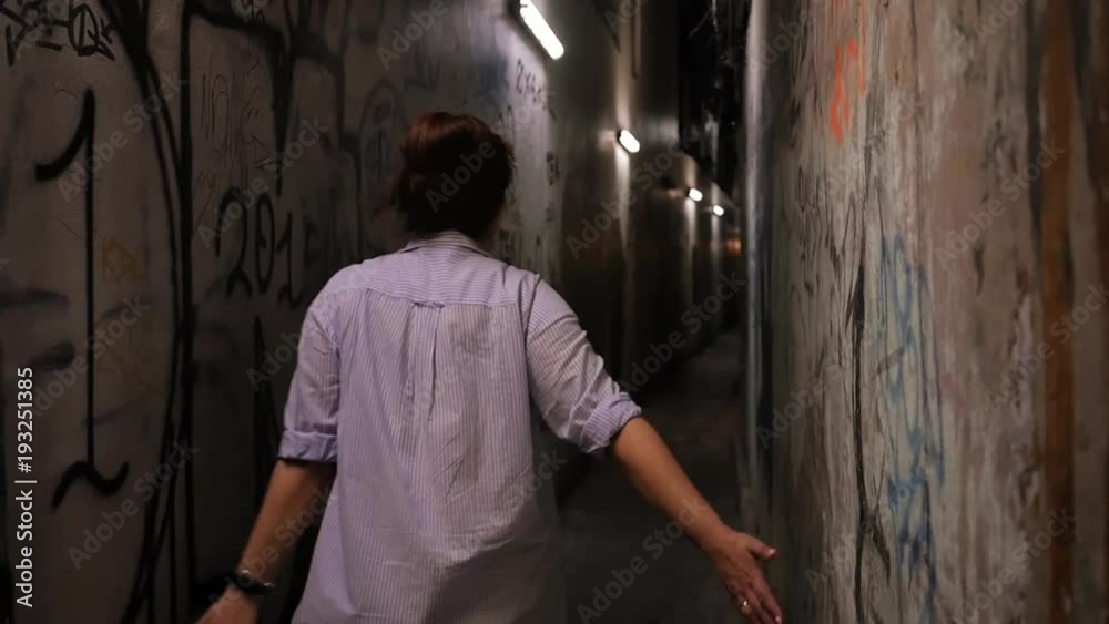 A joyful girl walks the evening alone through narrow dimly-lit alleys, where the walls are painted with graffiti. HD, 1920x1080, slow motion A joyful girl walks the evening alone through narrow dimly-lit alleys, where the walls are painted with graffiti. HD, 1920x1080, slow motion