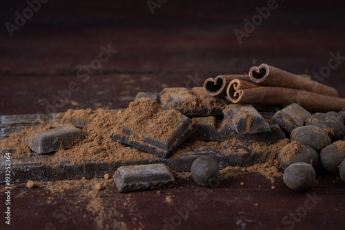 Chocolate, Spices, Spoon with Cocoa, Cinnamon, Nuts on Dark Wooden Background