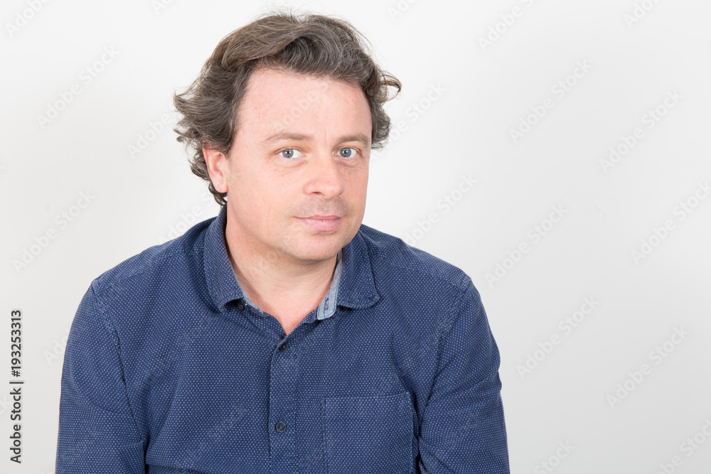 Portrait of smiling happy handsome man in casualsblue shirt on white background