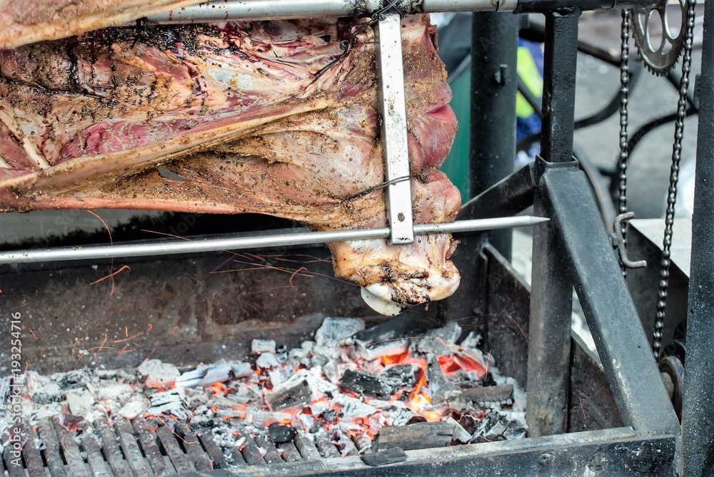 Carcasses of pork and other meat prepared on skewer. Cooking on grill and fire.
