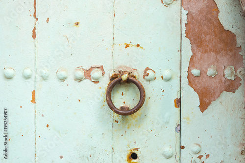 Fotografie Rusty iron ring on the wooden door