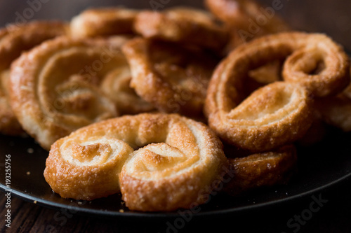 Palmier Cookies in Black Plate on Wooden Surface.