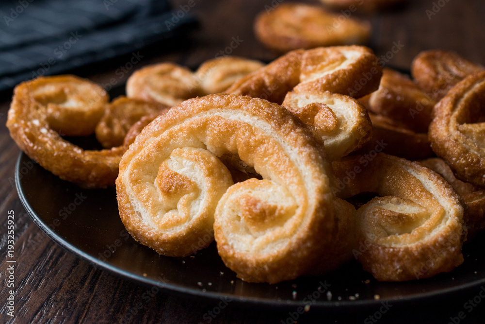 Palmier Cookies in Black Plate on Wooden Surface. Palmier Cookies in Black Plate on Wooden Surface.